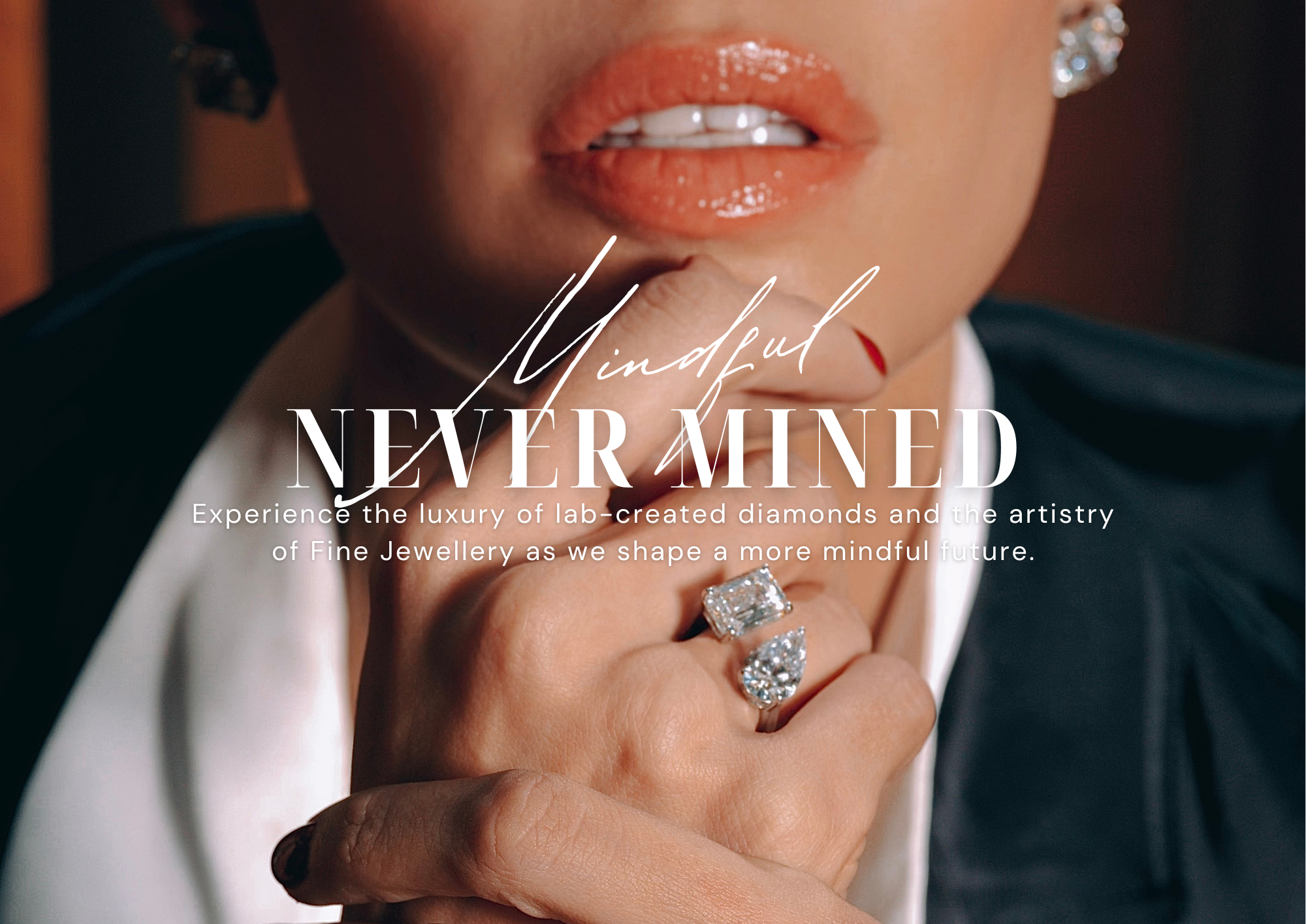 Close-up of a woman wearing lab-grown diamond jewelry, including bold radiant-cut and pear-shaped diamond rings and sparkling earrings. The text overlay reads 'Mindful NEVER MINED,' with a tagline promoting the luxury of lab-created diamonds and the artistry of fine jewelry.